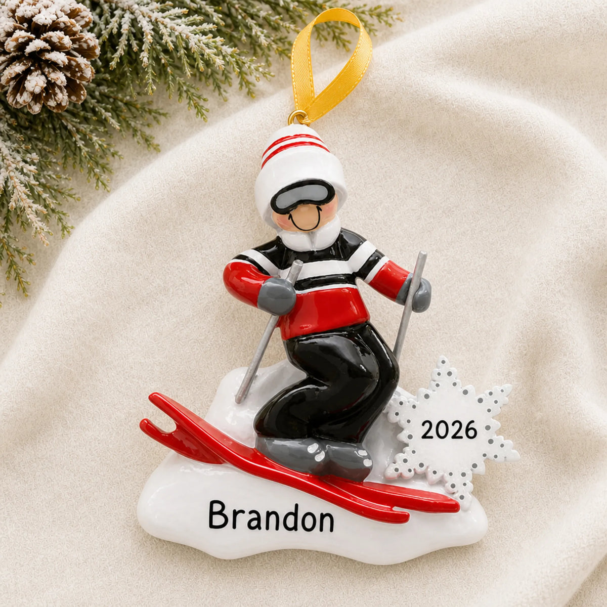 Personalized ski guy christmas ornament laid on a soft white knit blanket