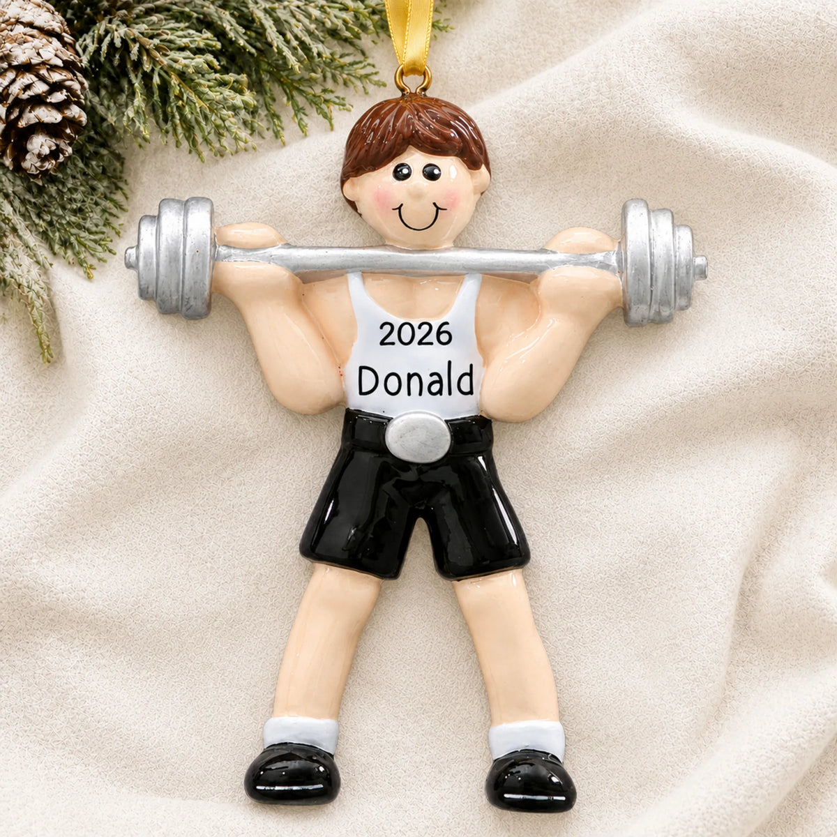 Personalized Weightlifter christmas ornament laid on a soft white knit blanket
