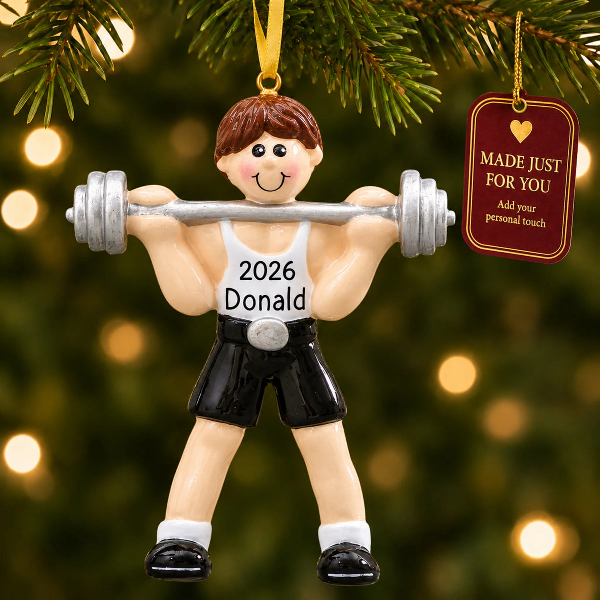 Weightlifter christmas ornament hanging on a lit Christmas tree with a Made Just For You gift tag