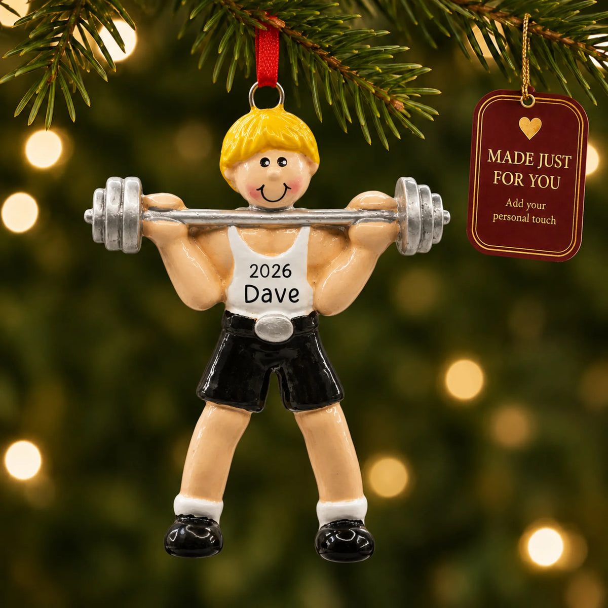 Blonde weightlifter christmas ornament hanging on a lit Christmas tree with a Made Just For You gift tag