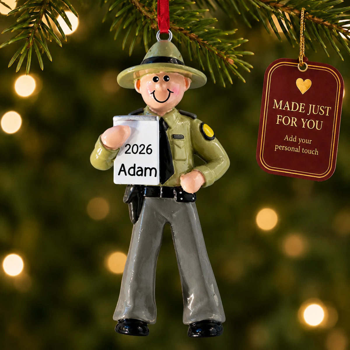 State trooper christmas ornament hanging on a lit Christmas tree with a Made Just For You gift tag