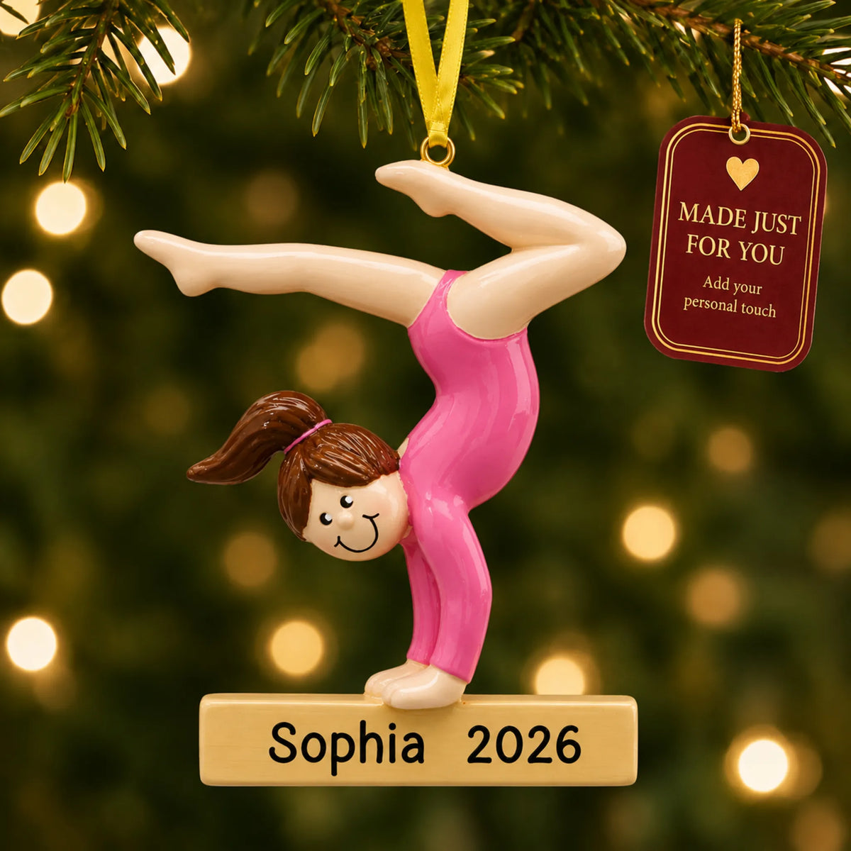 Gymnast balance beam christmas ornament hanging on a lit Christmas tree with a Made Just For You gift tag