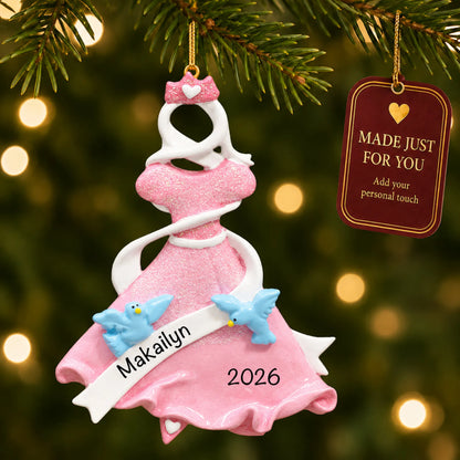 Pink princess dress christmas ornament hanging on a lit Christmas tree with a Made Just For You gift tag