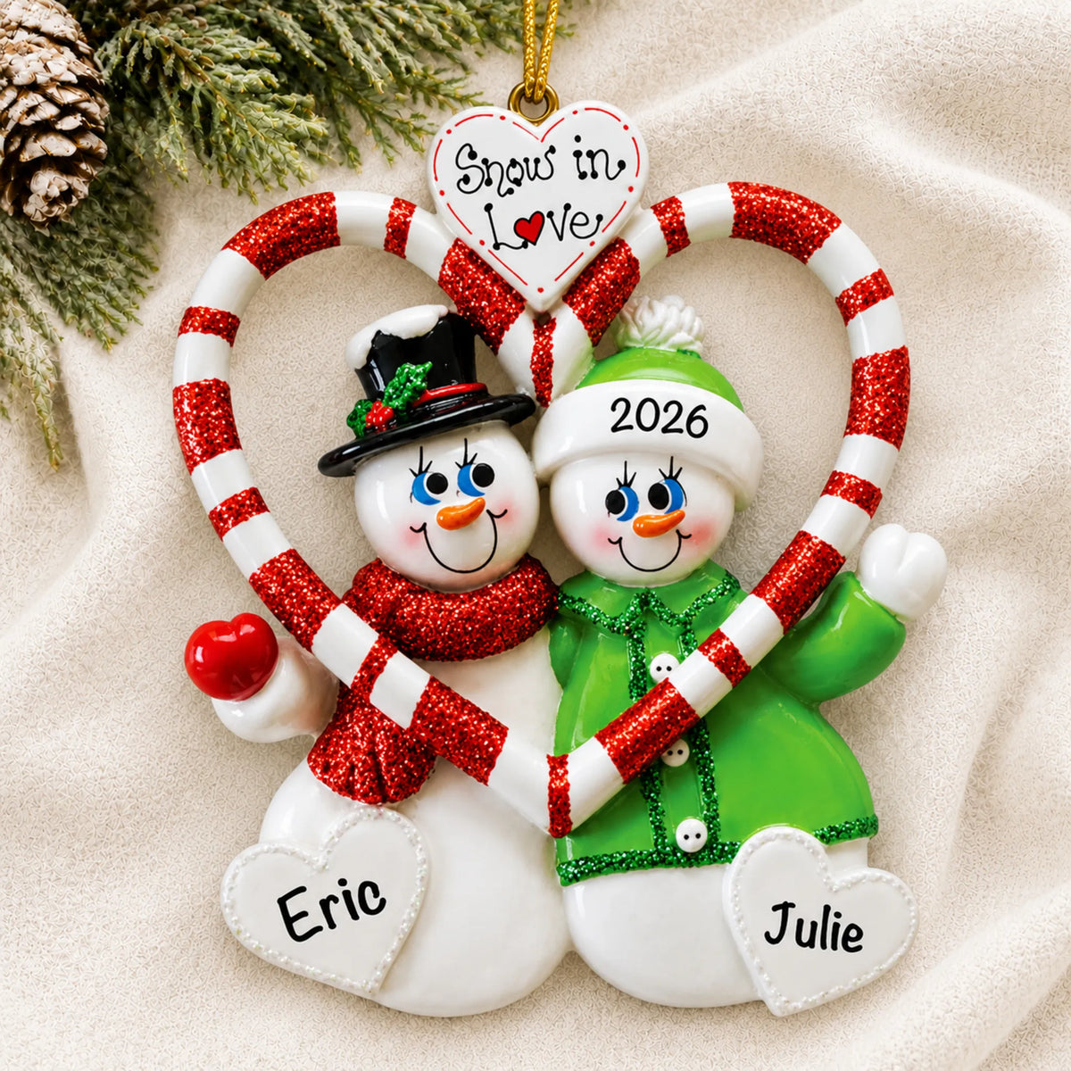 Personalized candy cane love couple christmas ornament laid on a soft white knit blanket
