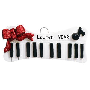 Personalized keyboard ornament with ivory keys and red bow, laser engraved with a name and year