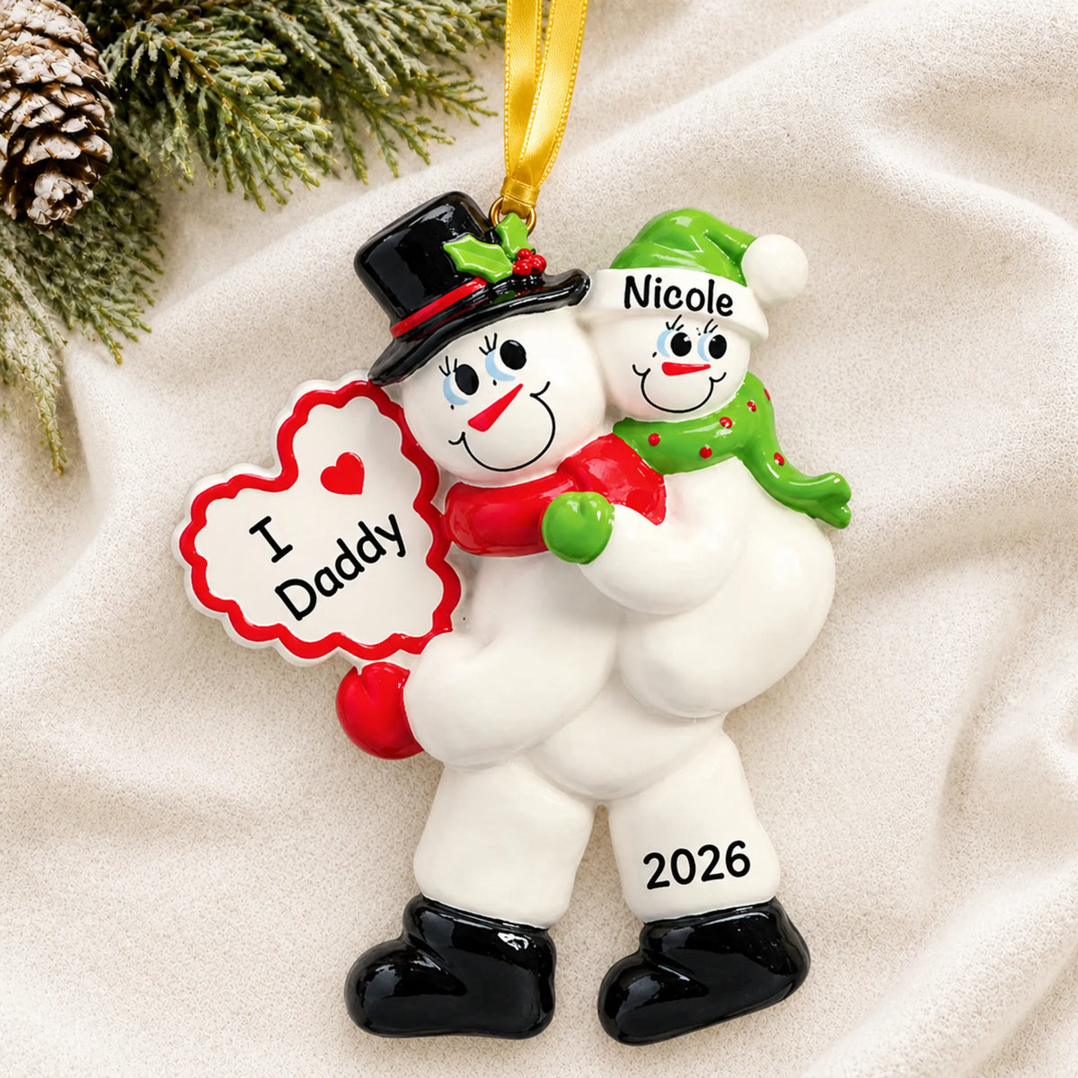 Personalized i love daddy christmas ornament laid on a soft white knit blanket