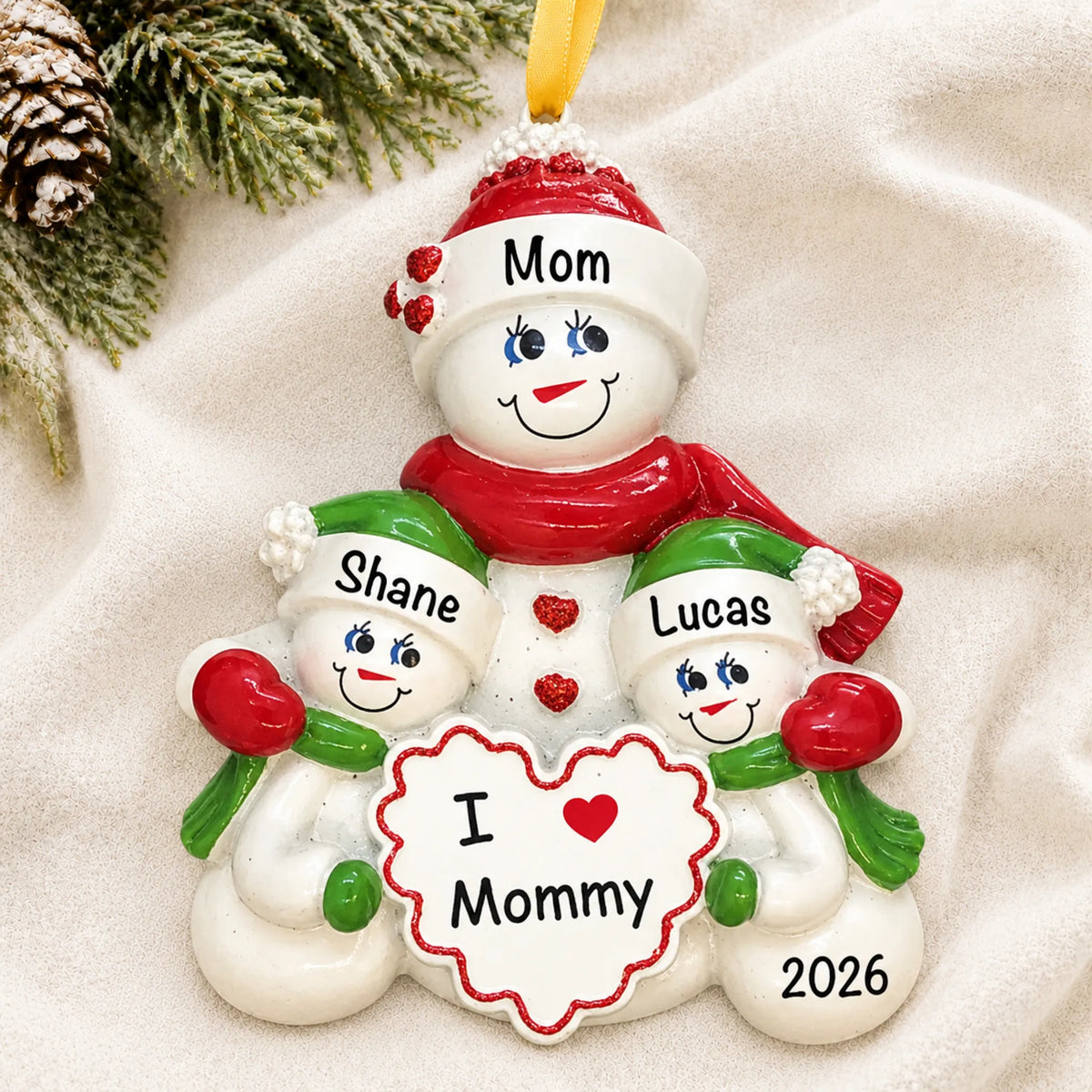 Personalized i love mommy christmas ornament laid on a soft white knit blanket