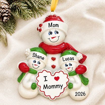 Personalized i love mommy christmas ornament laid on a soft white knit blanket