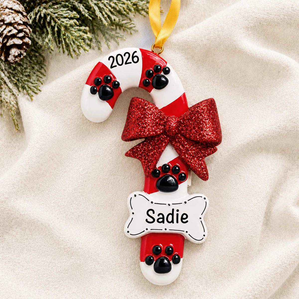 Personalized Dog Candy Cane christmas ornament laid on a soft white knit blanket