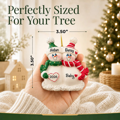 Size guide: the personalized Snow Couple Expecting christmas ornament is 3.50 in wide by 3.50 in tall, shown in hand