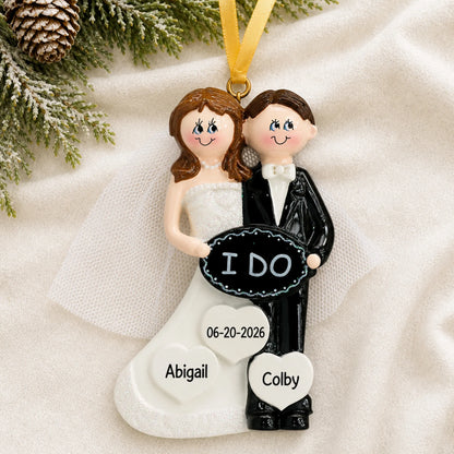 Personalized I Do wedding couple Christmas ornament on a cream knit blanket beside pine and pinecones
