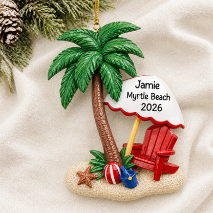 Personalized island oasis beach vacation christmas ornament laid on a soft white knit blanket