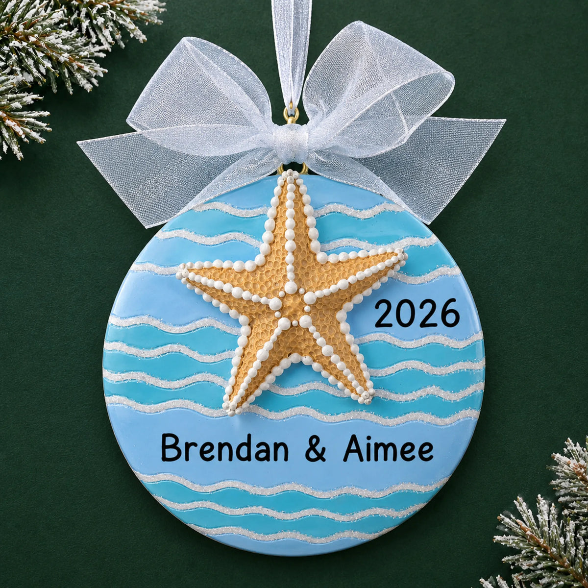 Personalized starfish beach christmas ornament on a dark green pine background