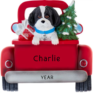 Personalized Black Shih Tzu Christmas ornament, the dog riding in a red vintage truck with a Christmas tree and presents in the back, the name laser engraved on the tailgate and the year on the bumper
