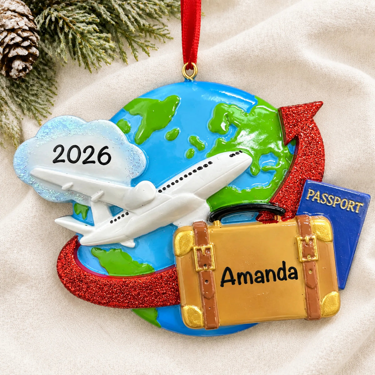 Personalized travel christmas ornament laid on a soft white knit blanket