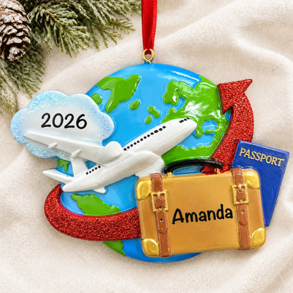 Personalized travel christmas ornament laid on a soft white knit blanket