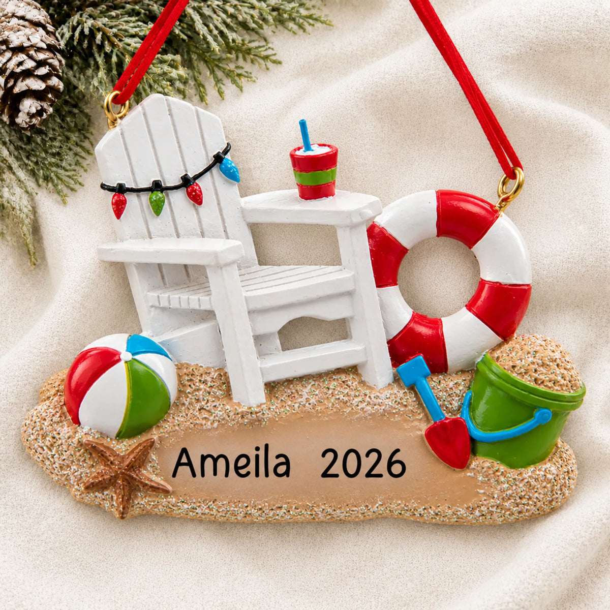 Personalized Adirondack beach chair christmas ornament laid on a soft white knit blanket