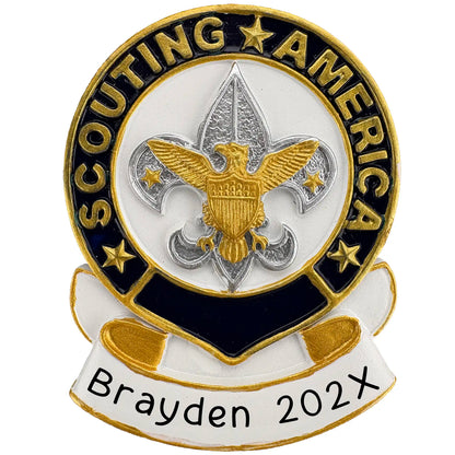 Personalized Christmas ornament featuring the gold and navy blue "Scouting America" emblem with the fleur-de-lis and eagle, set on a blank white banner ready for custom name engraving.