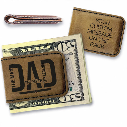 Brown leather money clip with 'DAD' engraving on a dollar bill, with another similar product in the background.