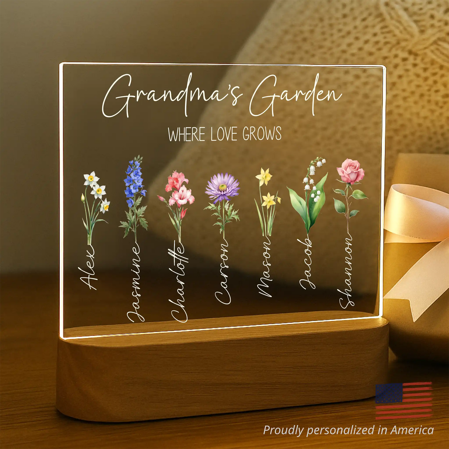 Personalized lighted sign with names of family members and floral designs on a wooden base.
