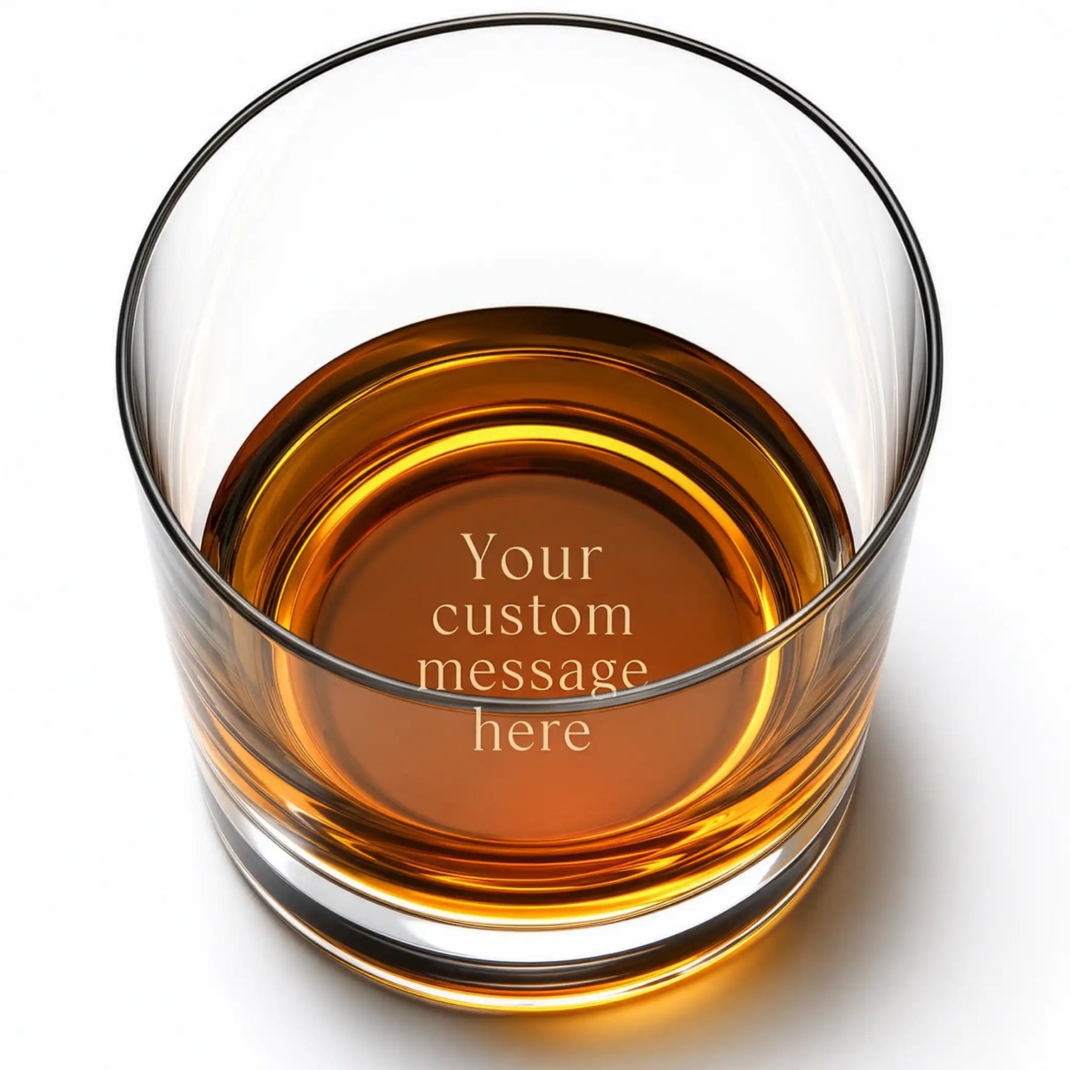 Personalized whiskey glass with custom engraved message on the base, shown with amber whiskey
