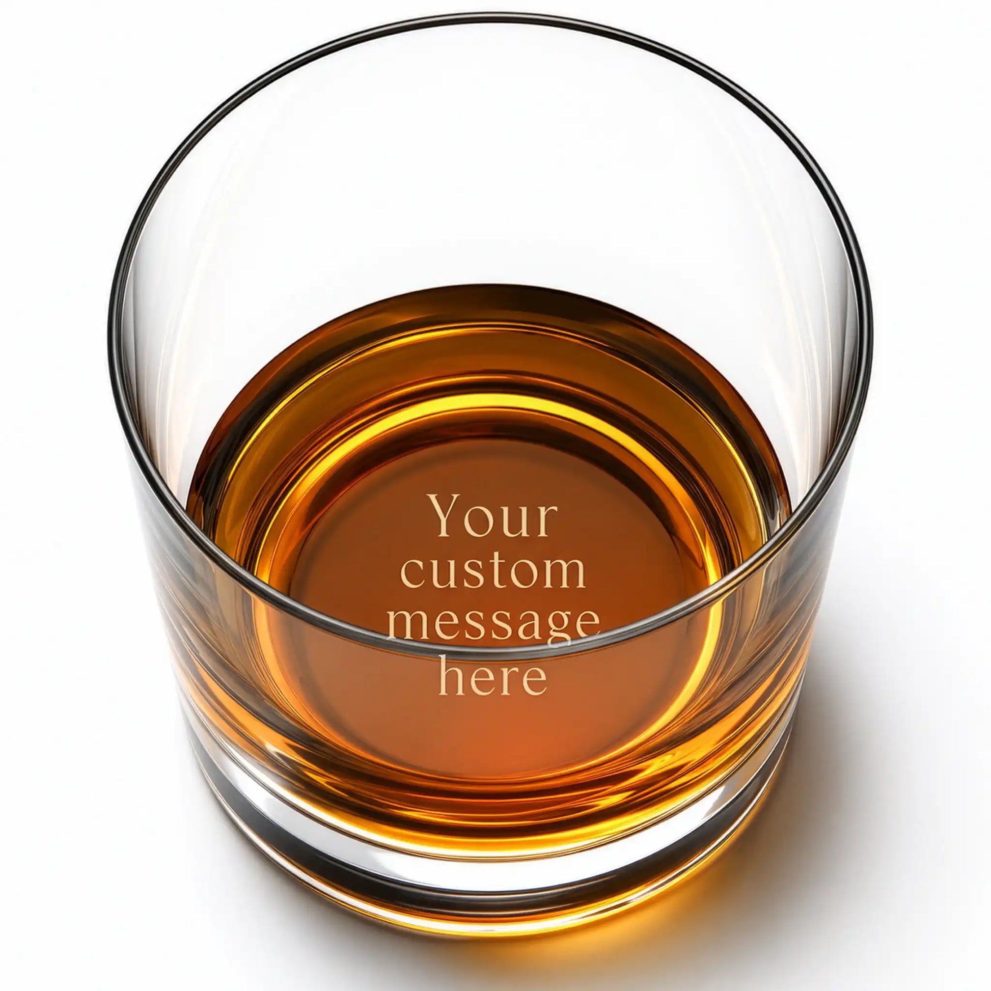 Personalized whiskey glass with custom engraved message on the base, shown with amber whiskey
