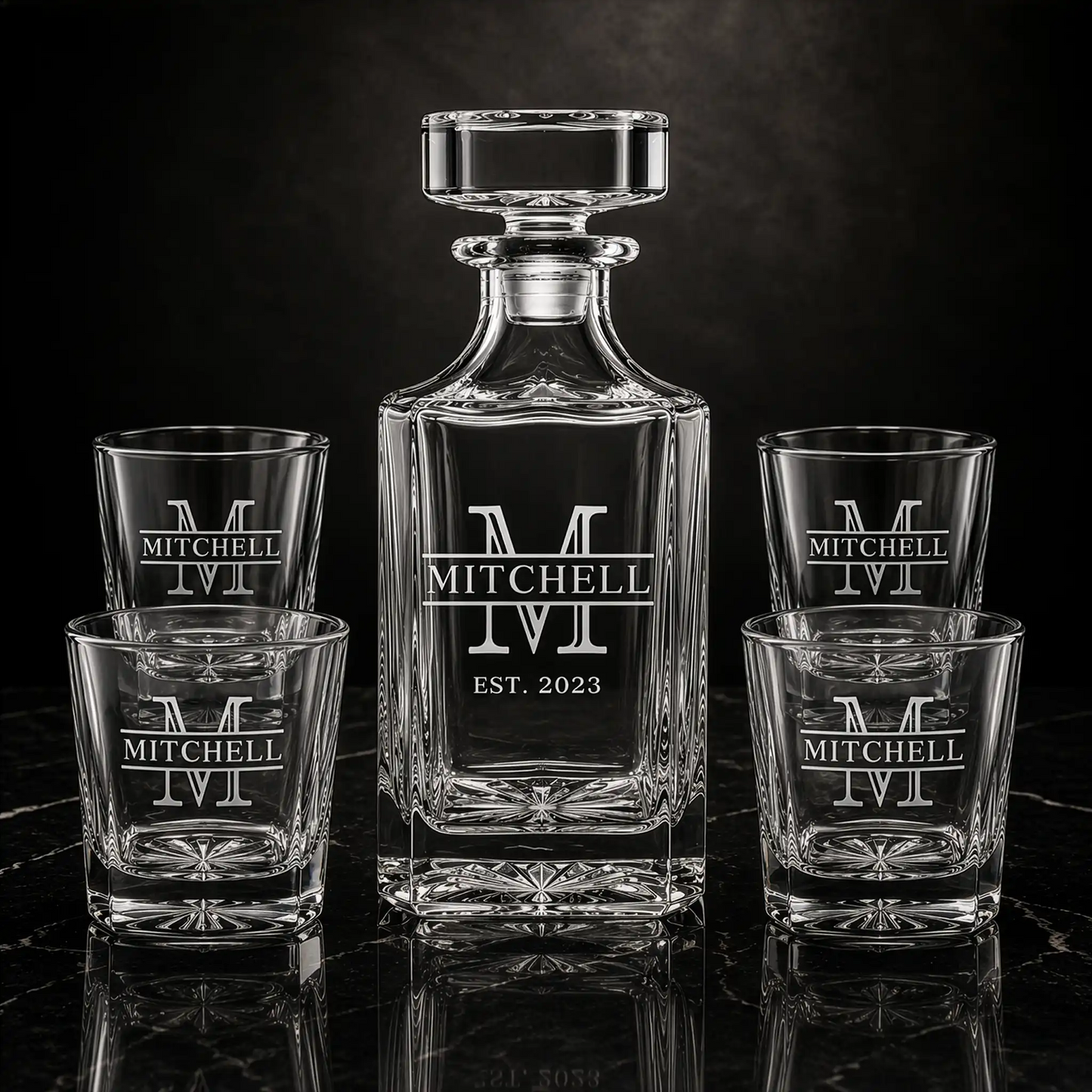 Personalized whiskey decanter and four matching rocks glasses engraved with Mitchell family name and EST. 2023 on black marble