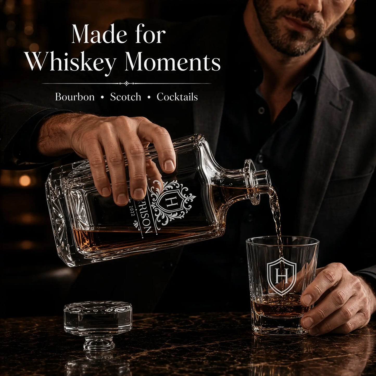 Engraved whiskey decanter pouring bourbon into matching personalized rocks glass in a luxury home bar