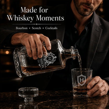 Engraved whiskey decanter pouring bourbon into matching personalized rocks glass in a luxury home bar