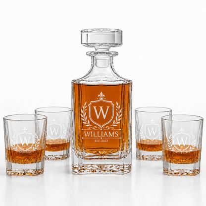Whiskey decanter set with four glasses featuring a monogram on a white background