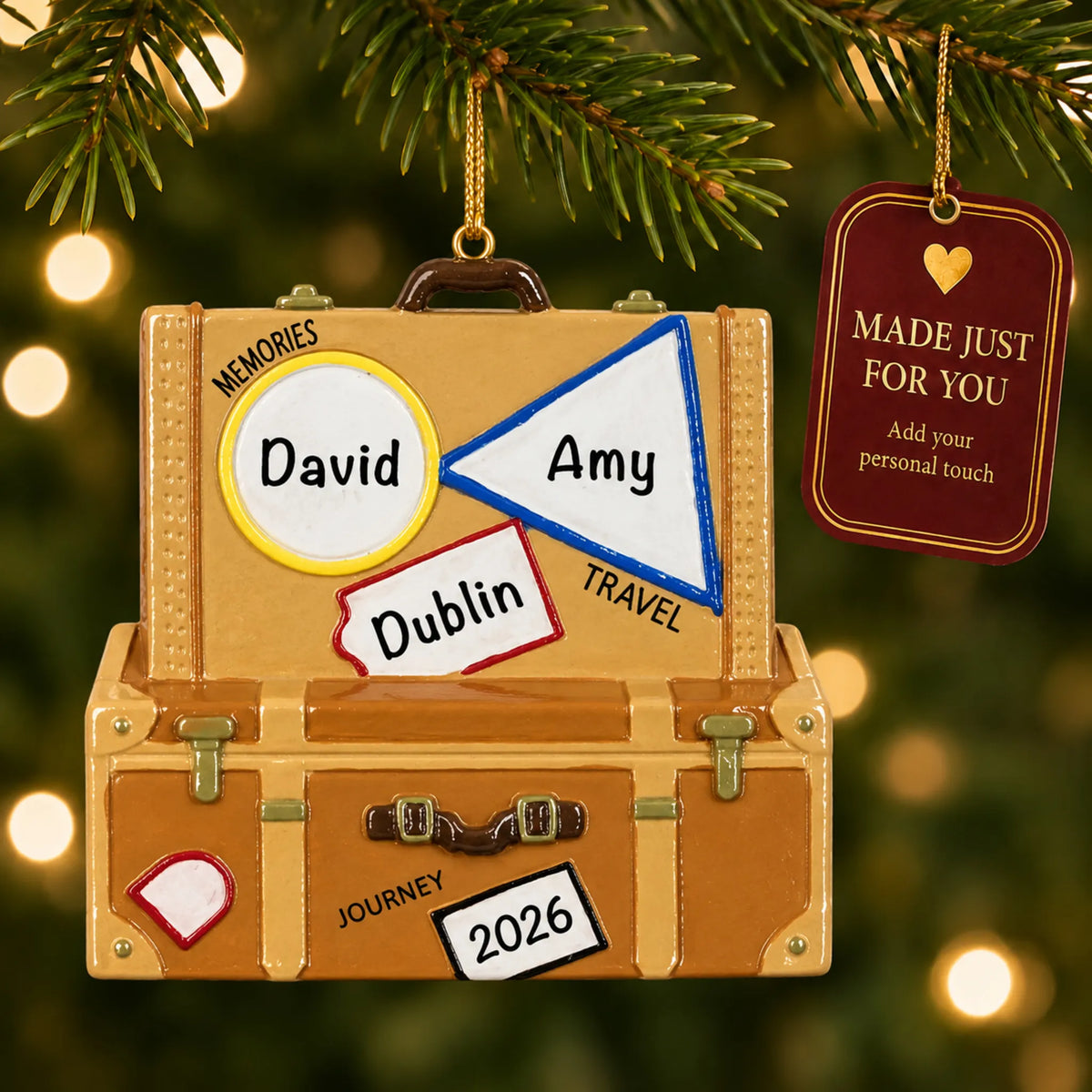 Travel suitcase christmas ornament hanging on a lit Christmas tree with a Made Just For You gift tag