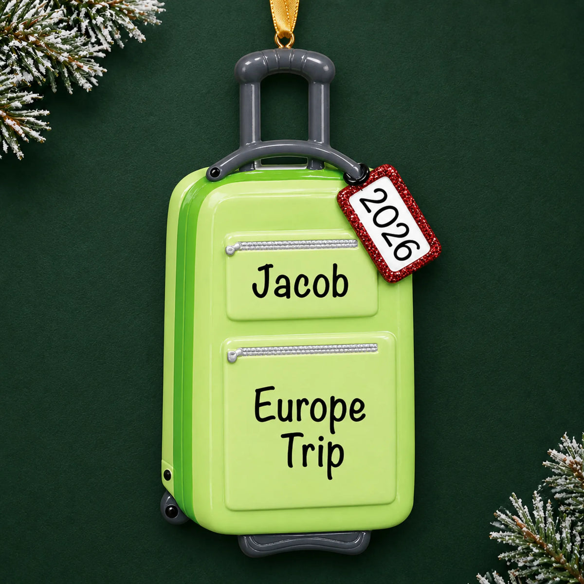 Personalized green travel suitcase christmas ornament on a dark green pine background