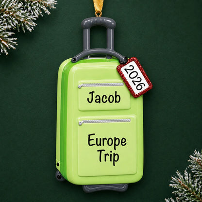 Personalized green travel suitcase christmas ornament on a dark green pine background