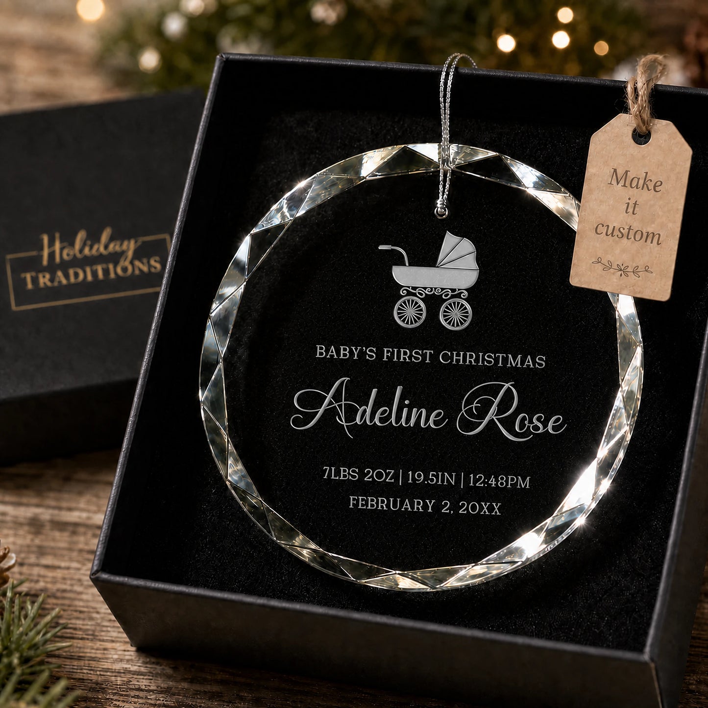 Baby's first Christmas personalized glass ornament with a baby carriage design, laser engraved with baby's name and birth stats, shown in its black gift box