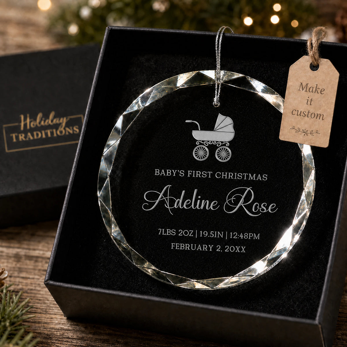 Baby's first Christmas personalized glass ornament with a baby carriage design, laser engraved with baby's name and birth stats, shown in its black gift box