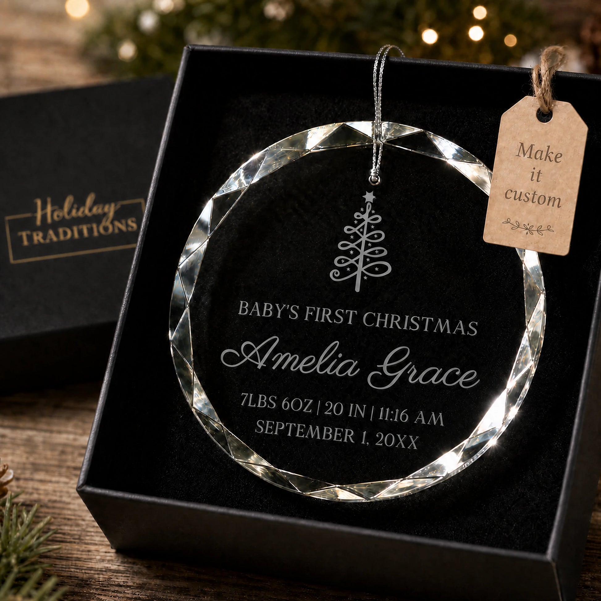 Baby's first Christmas personalized glass ornament with a Christmas tree design, laser engraved with baby's name and birth stats, shown in its black gift box