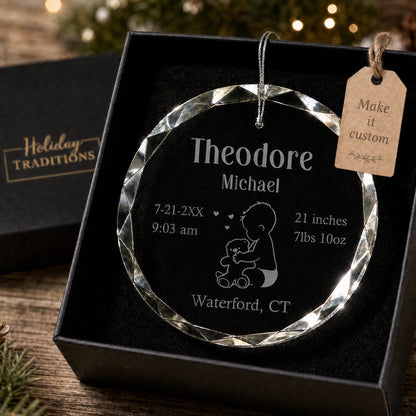 Baby's first Christmas personalized glass ornament with a baby and teddy bear design, laser engraved with baby's name, birth stats and birthplace, shown in its black gift box
