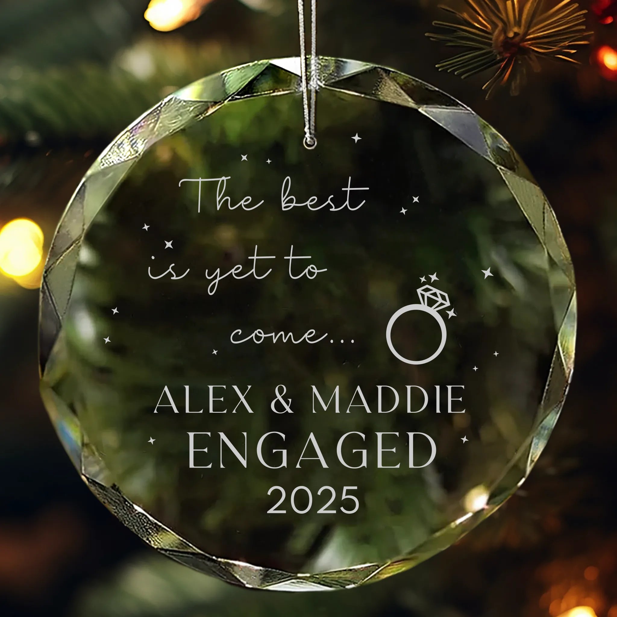 Personalized glass ornament engraved with “The best is yet to come with Names and Year of engagement” hanging on Christmas tree