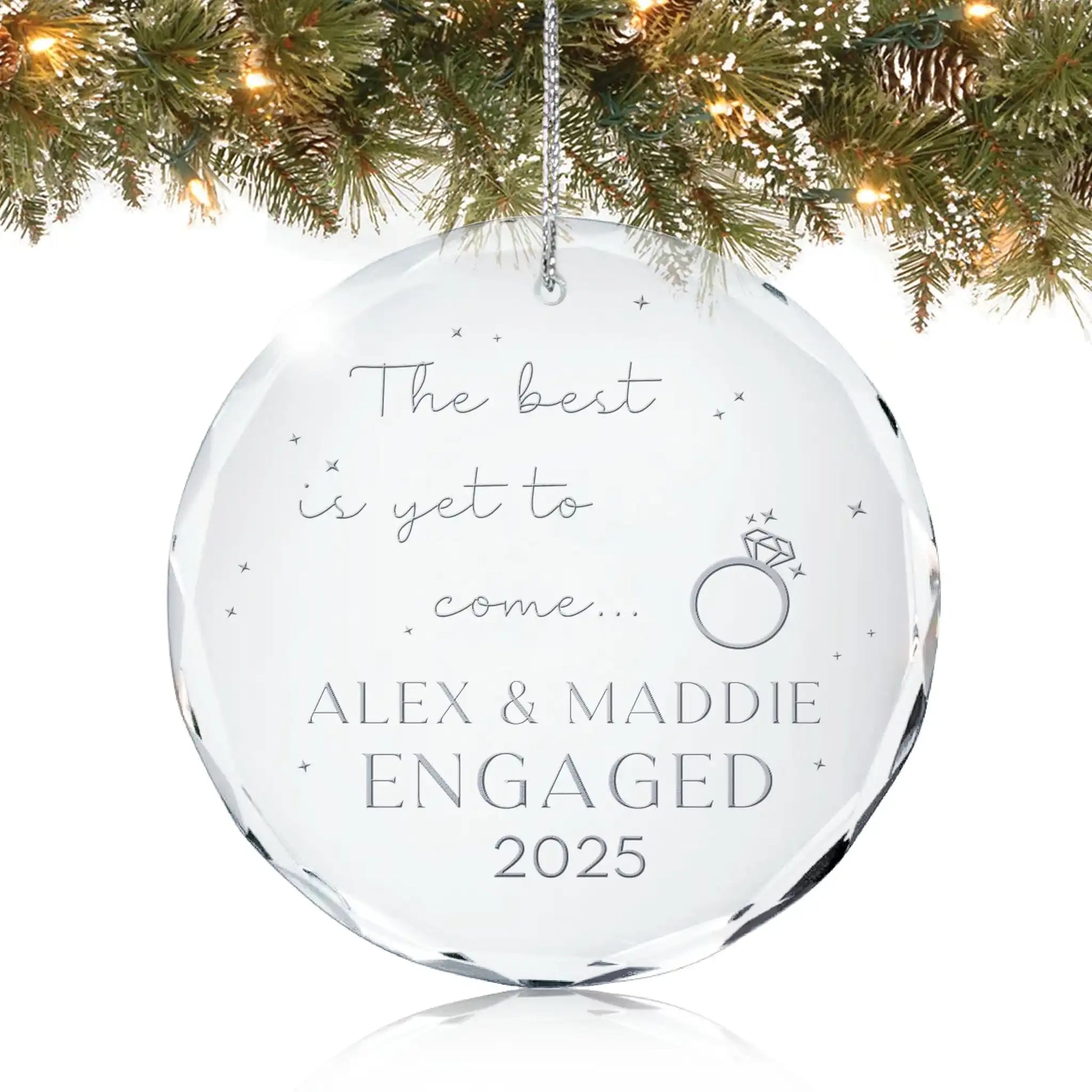 Personalized glass ornament engraved with “The best is yet to come with Names and Year of engagement” hanging on Christmas tree