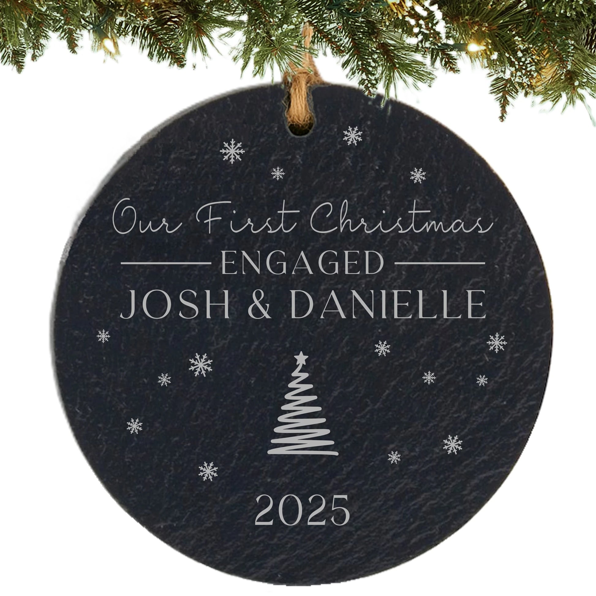 Black slate ornament engraved with “Our First Christmas Engaged,” couple’s names, snowflakes, and year.