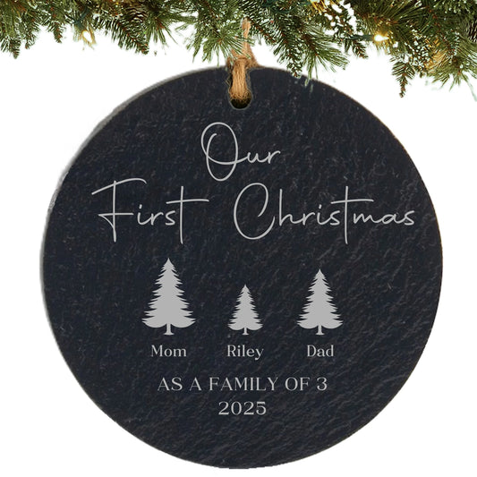 Slate ornament engraved with “Our First Christmas,” three tree icons with names, and “As a Family of 3” with the year.