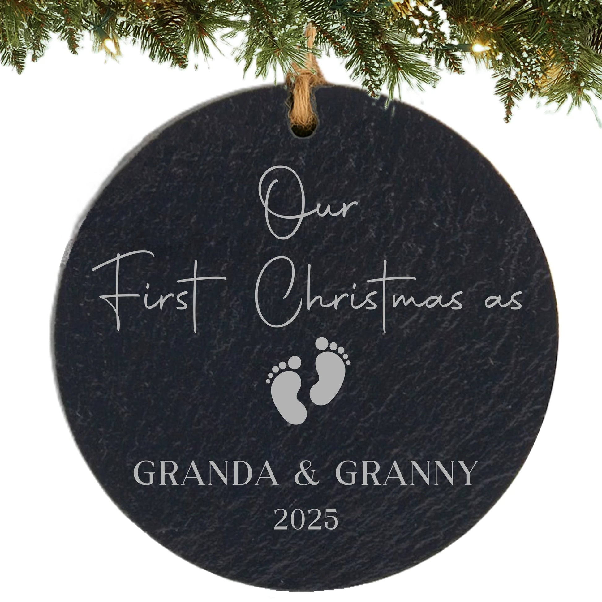 Slate ornament engraved with “Our First Christmas as,” baby footprints, grandparent names, and year.