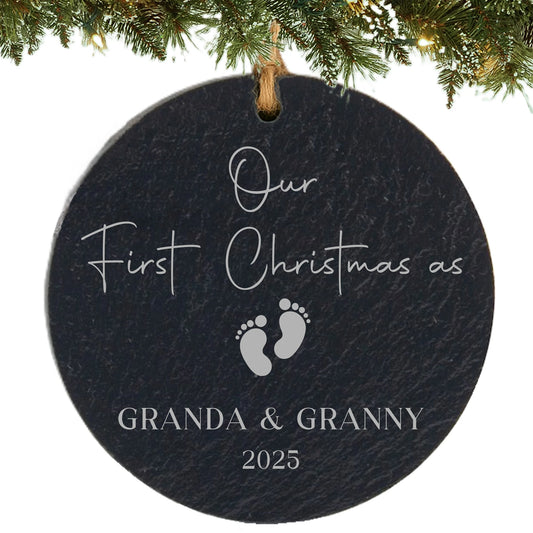 Slate ornament engraved with “Our First Christmas as,” baby footprints, grandparent names, and year.
