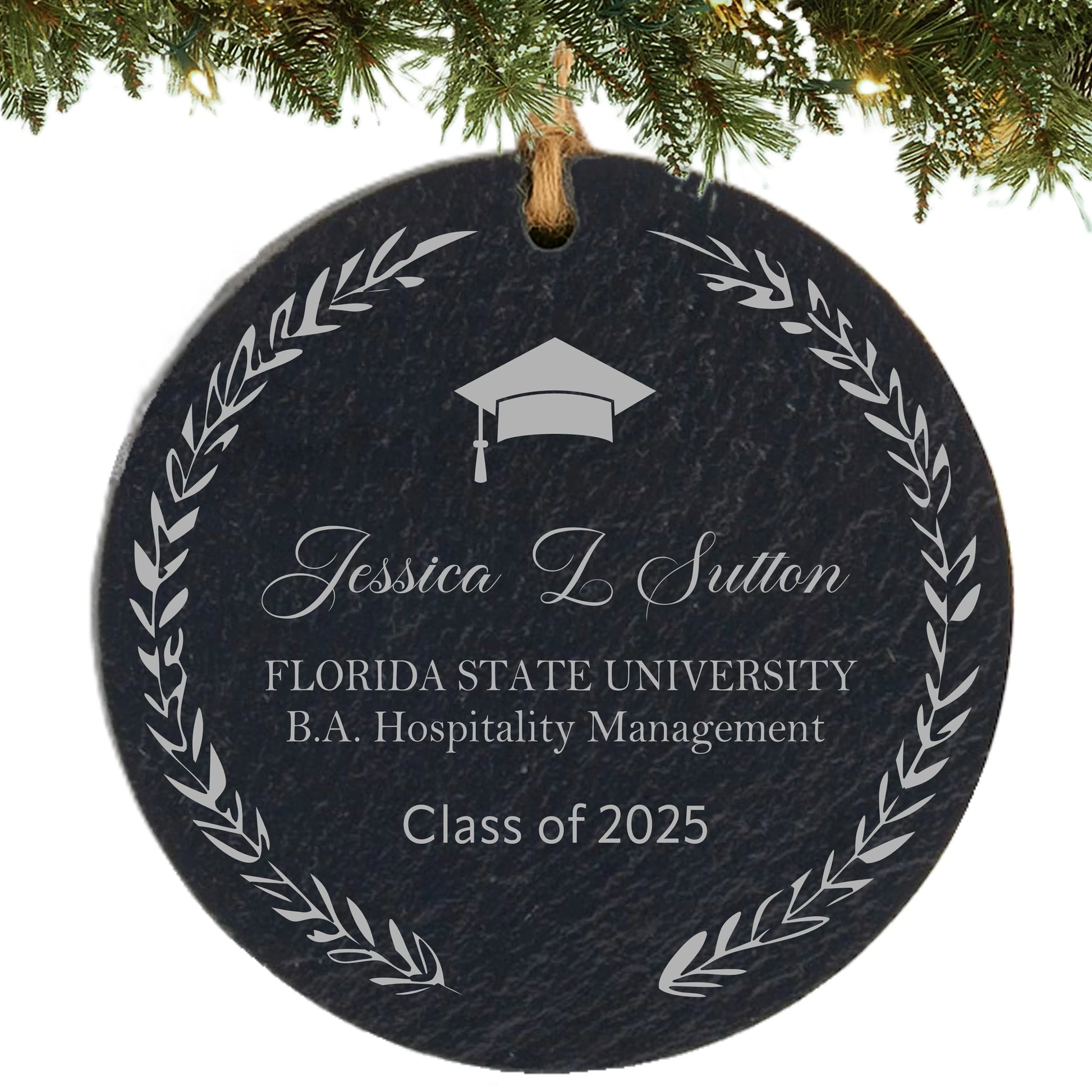 Slate ornament engraved with laurel wreath, graduation cap, graduate’s name, school, degree, and class year.