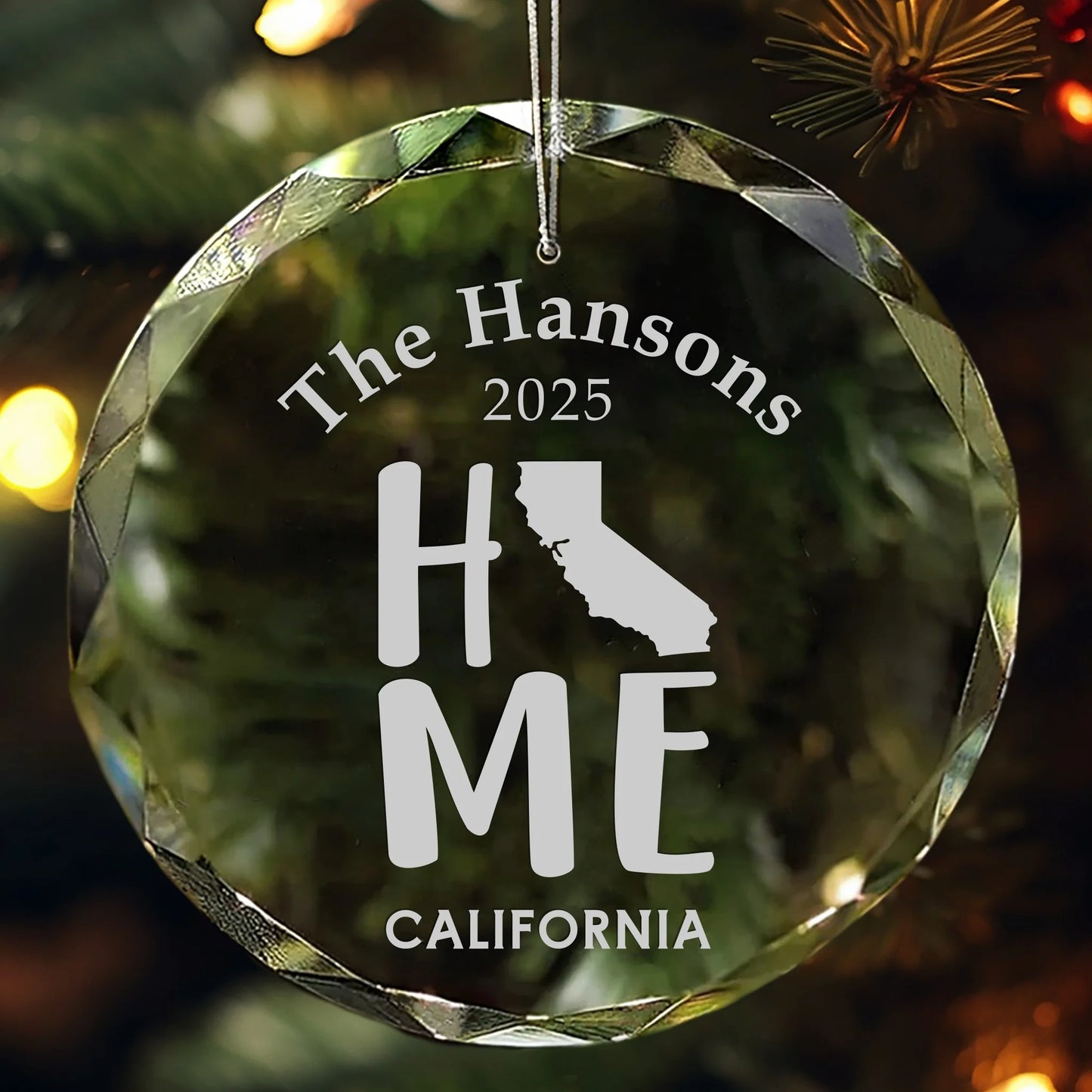 Personalized California glass ornament featuring the word “HOME” with the state outline, custom family name, and year engraved with a red ribbon for hanging.