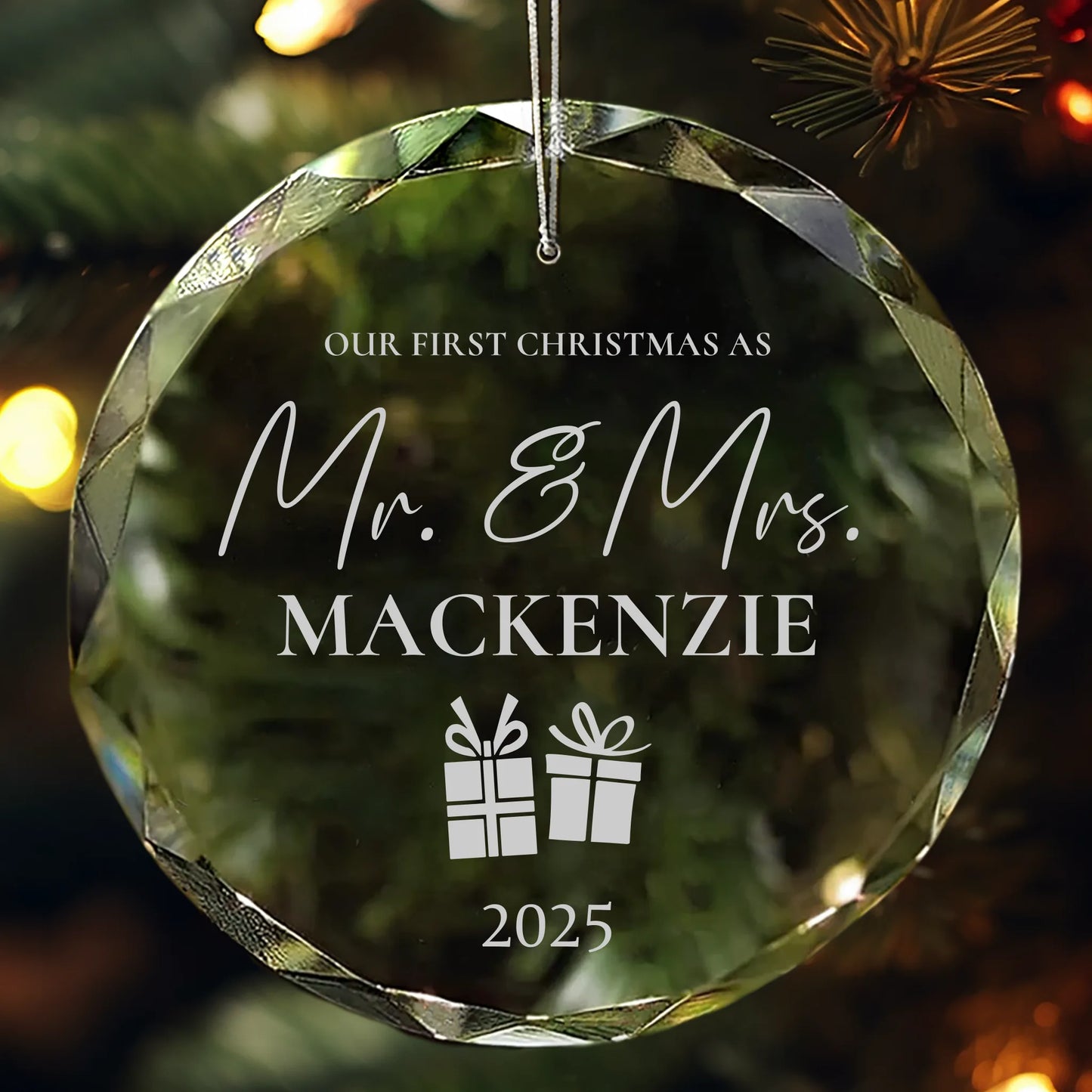 Personalized crystal ornament engraved with “Our First Christmas as Mr. & Mrs. with last name and year” featuring two gift box icons hanging on Christmas tree