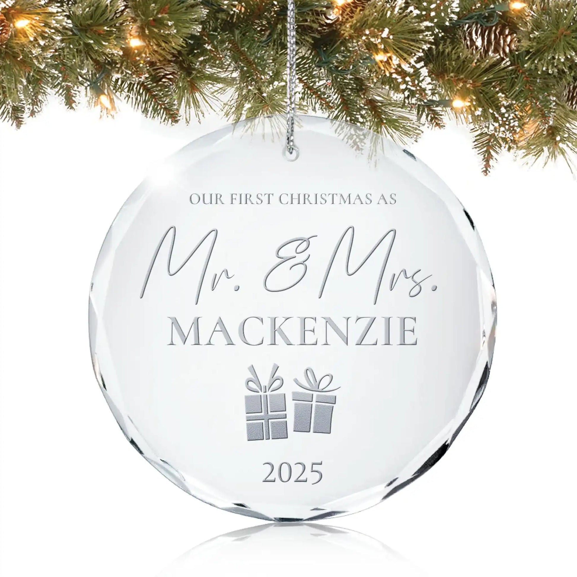 Personalized crystal ornament engraved with “Our First Christmas as Mr. & Mrs. with last name and year” featuring two gift box icons hanging on Christmas tree