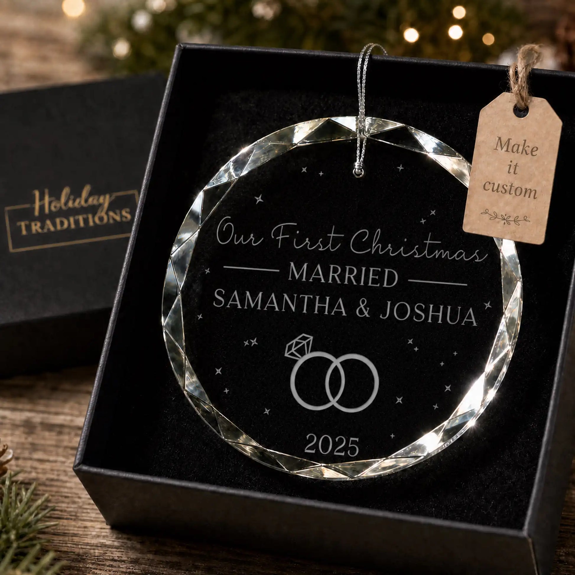 Our First Christmas Married personalized glass ornament with interlocking rings, laser engraved with the couple's names and year, shown in its black gift box