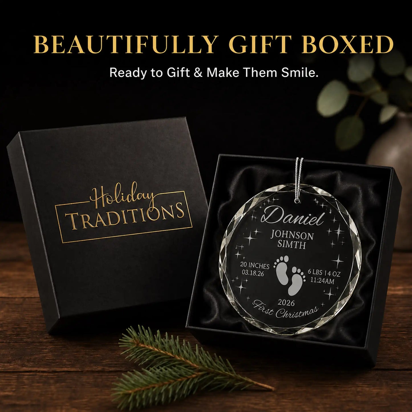 Footprints and stars personalized baby's first Christmas glass ornament arrives in a black Holiday Traditions gift box, ready to give