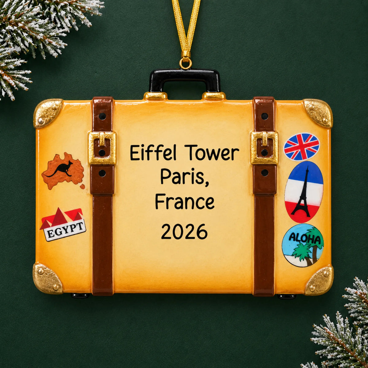 Personalized tan travel suitcase christmas ornament on a dark green pine background
